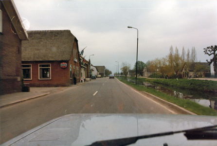 847737 Gezicht over de weg Dorp in Benschop vanuit de auto, voor de herinrichting van de weg; rechts de Benschopper Wetering.